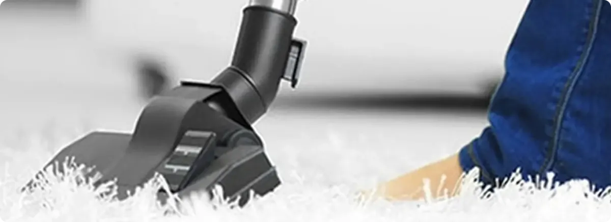 Close-up of a professional vacuuming a white carpet in Middleton.